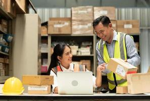 Warehouse Manager with female assistant Rethink a plan to prepare items that need to be sold to retailers during times of higher market prices. photo