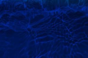 Defocus blurred blue water in swimming pool rippled water detail background. Water surface in the sea, ocean background. Water is an inorganic, transparent, tasteless, odorless, and nearly colorless. photo