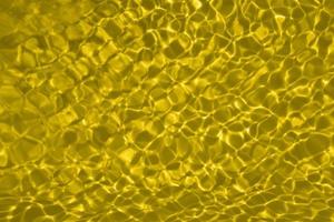 Defocus blurred yellow watercolor in swimming pool rippled water detail background. Water splash, water spray background. photo