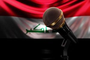 micrófono en el fondo de la bandera nacional de irak, ilustración 3d realista. premio de música, karaoke, radio y equipo de sonido de estudio de grabación foto
