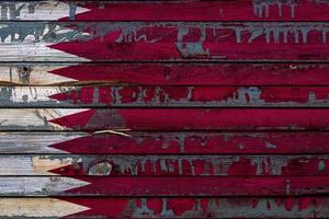 The national flag of Qatar is painted on uneven boards. Country symbol. photo