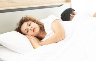 Family relationship problem concept.  Couple lying in bed under white blanket. photo