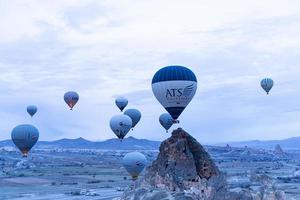 goreme, turquía, 2019 - turistas montando el colorido globo aerostático que vuela sobre goreme, paisaje de capadocia foto