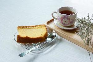 Having breakfast with Chinese tea with soft cake decorated with dried flower at work from home workspace. photo