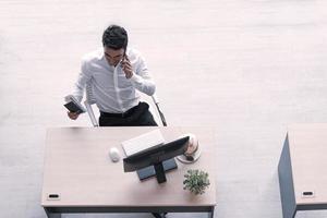 Top view of executive, manager, or engineer drinking coconut juice working on computer using smartphone in social distancing creative office. photo