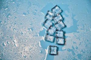 cubitos de hielo sobre fondo azul de estudio. el concepto de frescura con frialdad de cubitos de hielo. foto