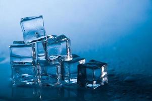 cubitos de hielo sobre fondo azul de estudio. el concepto de frescura con frialdad de cubitos de hielo. foto