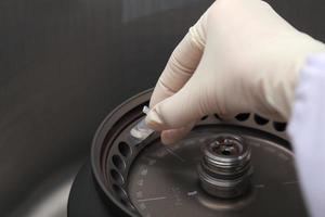 Scientist loading a sample to centrifuge photo