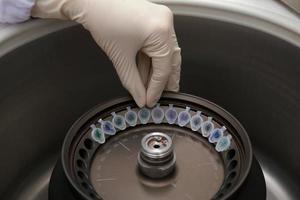 Scientist loading a sample to centrifuge photo