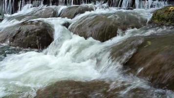 The stream flows through the rocks and rocks in the stream. video