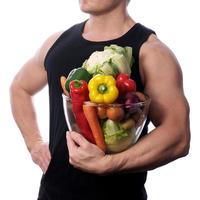 Raw food man holding vegetables and fruit photo