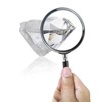 An expert examines through a magnifying glass. Searching For Value, diamond photo