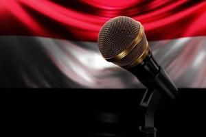 micrófono en el fondo de la bandera nacional de yemen, ilustración 3d realista. premio de música, karaoke, radio y equipo de sonido de estudio de grabación foto