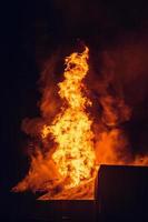 House on fire at night. Topics of arson and fires, disasters and extreme events. photo