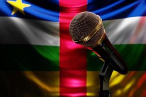 micrófono en el fondo de la bandera nacional de la república centroafricana, ilustración 3d realista. premio de música, karaoke, radio y equipo de sonido de estudio de grabación foto