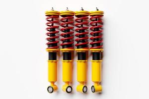 Four colorful shock absorber car on white background. 3d illustration. Suspension Parts photo