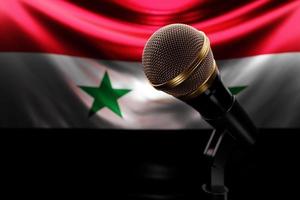 micrófono en el fondo de la bandera nacional de siria, ilustración 3d realista. premio de música, karaoke, radio y equipo de sonido de estudio de grabación foto