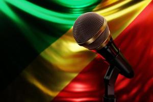 micrófono en el fondo de la bandera nacional de la república del congo, ilustración 3d realista. premio de música, karaoke, radio y equipo de sonido de estudio de grabación foto