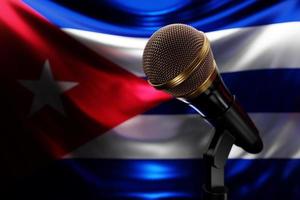 micrófono en el fondo de la bandera nacional de cuba, ilustración 3d realista. premio de música, karaoke, radio y equipo de sonido de estudio de grabación foto