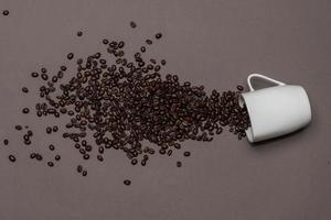 Coffee beans and white cup on coloured background photo