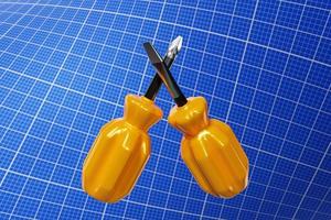 Ilustración 3d de destornilladores con mango amarillo en estilo de dibujos animados en papel cuadriculado. herramienta de carpintería manual para tienda de bricolaje. foto