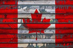 The national flag of Canada is painted on uneven boards. Country symbol. photo