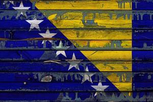 The national flag of Bosnia Herzegovina is painted on uneven boards. Country symbol. photo