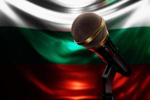 micrófono en el fondo de la bandera nacional de bulgaria, ilustración 3d realista. premio de música, karaoke, radio y equipo de sonido de estudio de grabación foto