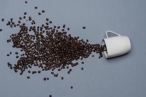 Coffee beans and white cup on coloured background photo