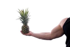 Muscular man holding fruits and vegetables photo