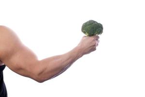 hombre musculoso sosteniendo frutas y verduras foto