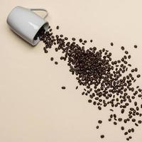 Coffee beans and white cup on coloured background photo