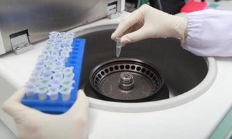 Scientist loading a sample to centrifuge photo