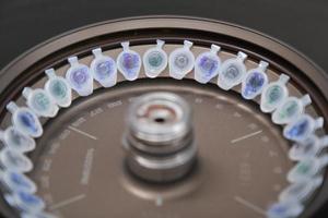 Scientist loading a sample to centrifuge photo