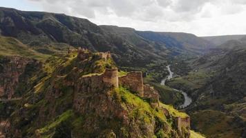 vue aérienne en hausse de la forteresse de tmogvi sur la colline à distance avec un ciel dramatique au-dessus. sites historiques en géorgie. video