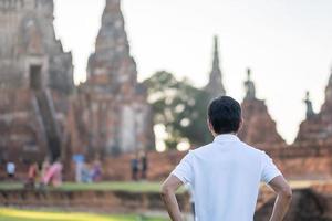 Tourist Man visiting to ancient stupa in Wat Chaiwatthanaram temple in Ayutthaya Historical Park, summer, solo, Asia and Thailand travel concept photo