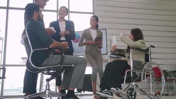 een gehandicapte medewerker van het bedrijf kan prettig samenwerken met collega's op kantoor. video