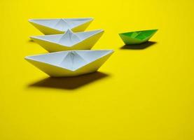 white and green paper boat yellow background in an orderly manner, providing ideas, leadership and effective management give a feeling have solidarity success, love, happiness, great