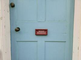 letrero rojo de residencia privada en la puerta de madera azul en casa foto