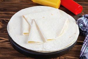 Round lavash on a wooden background. Isolated pita bread photo