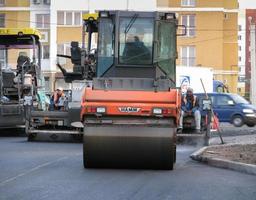 Ukraine, Kharkiv, October 27, 2020. Close-up view on the workers and the asphalting machines. Roller and workers on asphalting and repair of city streets. High quality photo