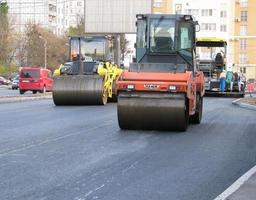 Ukraine, Kharkiv, October 27, 2020. Close-up view on the workers and the asphalting machines. Roller and workers on asphalting and repair of city streets. High quality photo