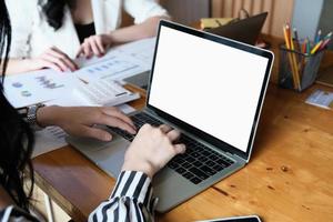 freelance concept, Woman using computers  laptop on wooden desk blur background. Laptop computer with blank screen and can be add your texts or others on screen. photo