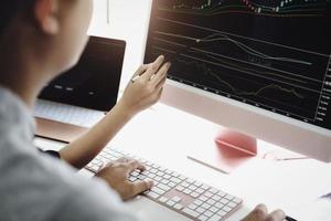 An investment expert points a pen at a tablet monitor to analyze the stock market to teach you how to make a profit. photo