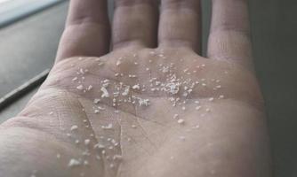 Close-up side shot of microplastics on human fingers. Concept for water pollution and global warming. Climate change idea. Soft focus on a bunch of micro plastic that cannot be recycled. photo