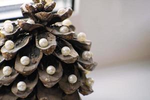 Pine cone in the form of a New Year tree. Christmas tree. Pine cone decorated with pearls. photo