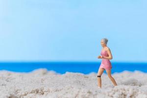 Miniature people running on The beach photo