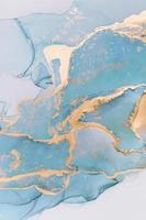 Abstract liquid ink painting background in pastel colors with gold splashes photo