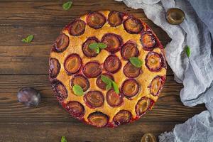 Delicious homemade plum pie on rustic background. Top view