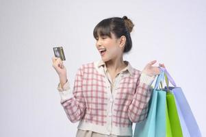 Shopper atractiva mujer sosteniendo bolsas de compras sobre fondo blanco. foto